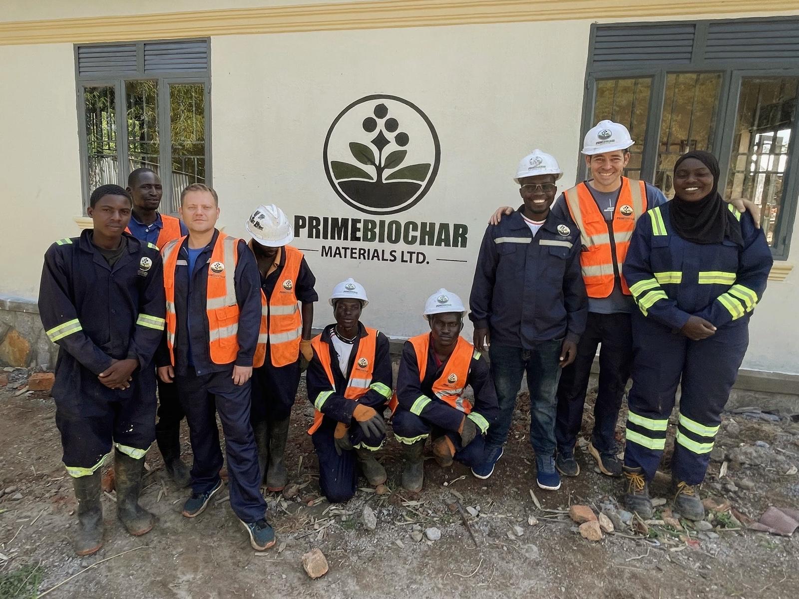 The PrimeBiochar team in front of the company logo